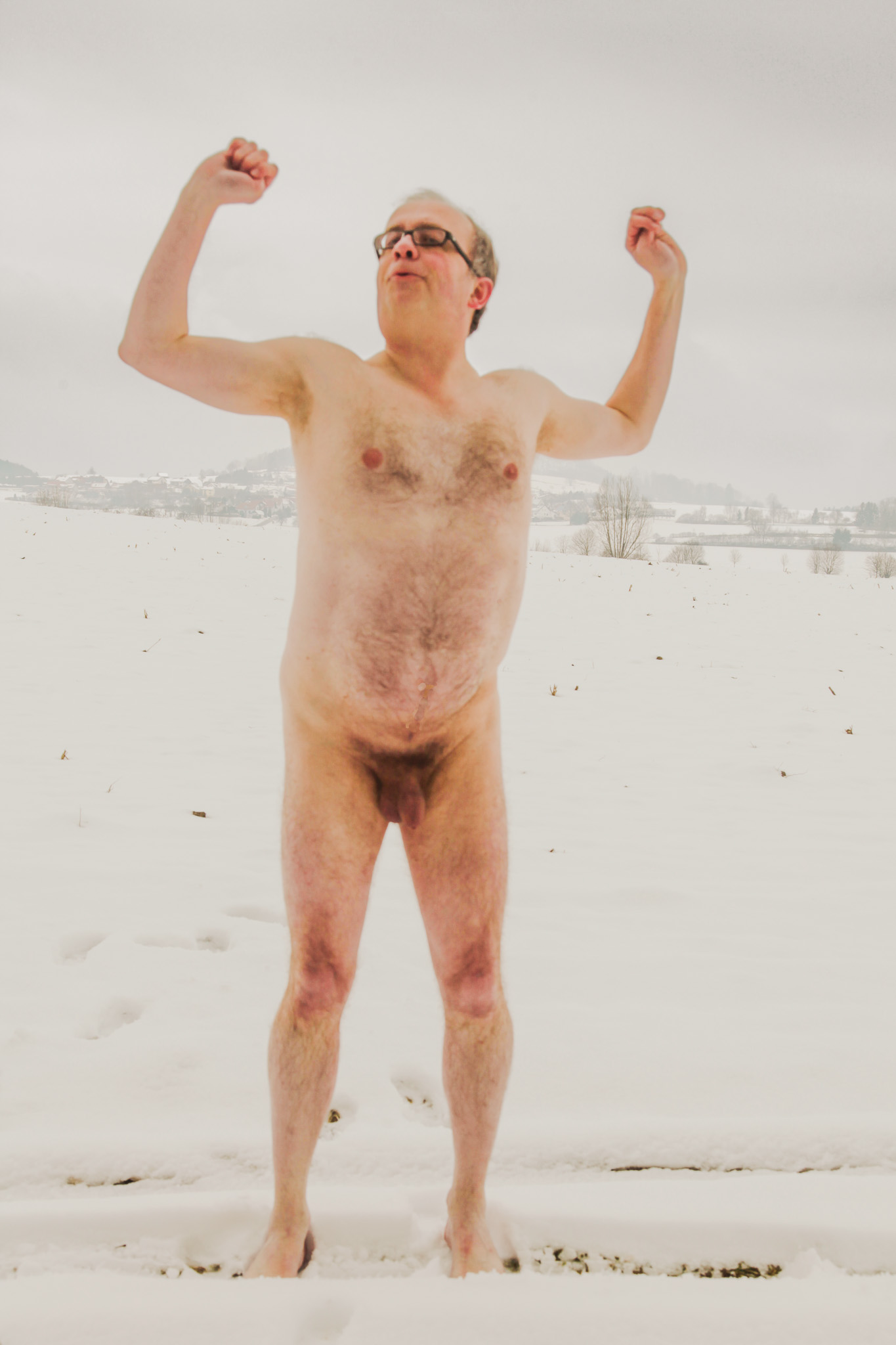 Male nude has fun in the snow showing his genitals in front of the Bussen in Upper Swabia